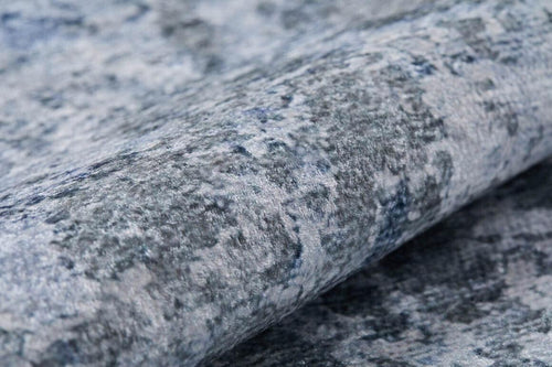 Bild 1 in Galerieansicht laden. Close-up of Abstract Oasis - Washable Rug - JR144 (Outlet) US, featuring a rolled-up, textured surface in mottled blue, gray, and white—perfect for allergy-sensitive homes or high-traffic areas.