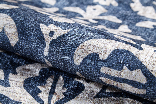 Load image 1 in gallery view. A close-up of the Antique Flourish - Washable Rug - JR1591 shows its textured surface with a bold, abstract floral and leaf pattern in dark blue and beige—perfect as a stylish, washable rug for high-traffic areas.