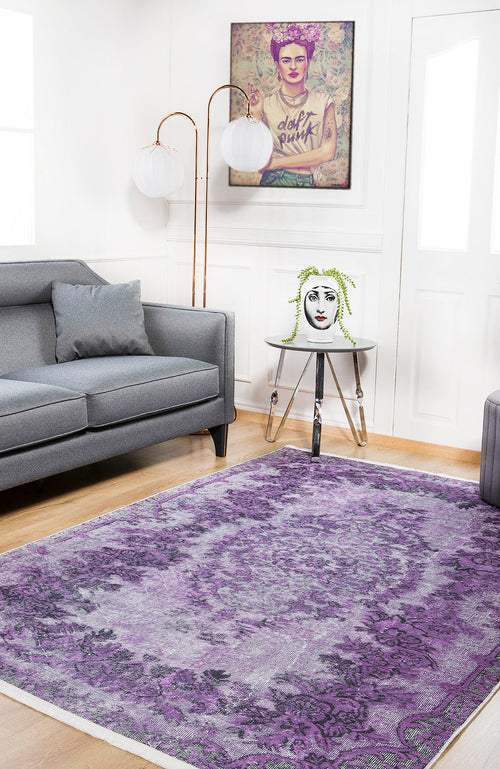 Bild 1 in Galerieansicht laden. A modern living room with a gray sofa, the Artisan Tapestry - Washable Rug - JR176 (purple patterned, ideal for high-traffic areas), a side table with a vase, framed tattooed art, and two white globe lamps behind the sofa.