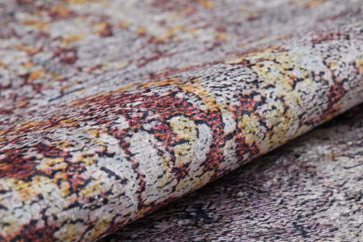A close-up of the Artistic Abstraction - Washable Rug - JR775 reveals its abstract pattern in gray, yellow, orange, and red tones, with detailed fibers and a subtly raised surface.