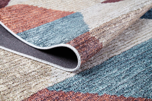Load image 1 in gallery view. A close-up of the Asymmetrical Wonder - Washable Rug - JR1725, featuring a blue, beige, and rust pattern with visible edge stitching—ideal for allergy-sensitive homes or high-traffic areas.