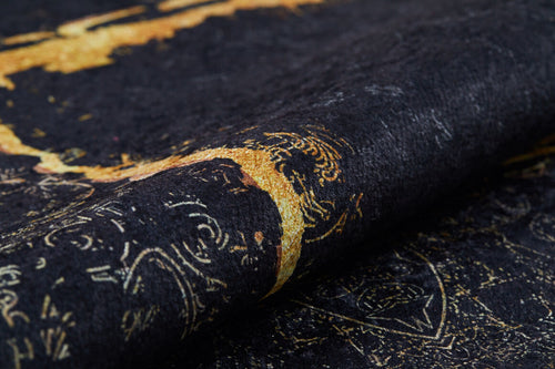 Load image 1 in gallery view. A close-up of the Azure Glow - Washable Rug - JR1337 shows its black base with gold textured fabric, ornate metallic-accented patterns, and a luxurious feel—ideal for high-traffic spaces.