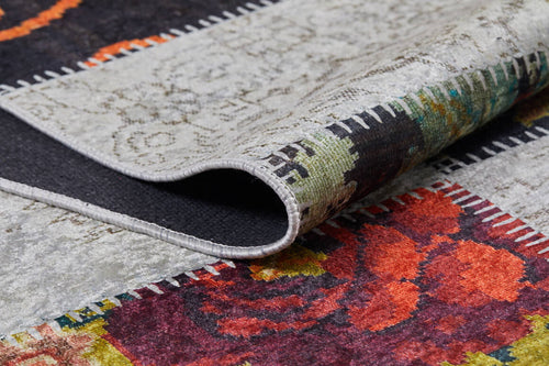 Load image 1 in gallery view. A close-up of the Blooming Paradise - Washable Rug - JR188 shows its folded edge, vibrant floral and geometric patterns in red, orange, green, and gray, and contrasting stitched borders—perfect for high-traffic areas.