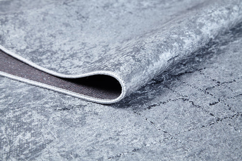 Bild 1 in Galerieansicht laden. A close-up of the Bohemian Driftwood - Washable Rug - JR1951 in gray-anthracite shows its soft top, grid-patterned non-slip backing, and slightly raised edge—ideal for high-traffic areas and easy cleaning.