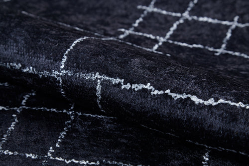 Load image 1 in gallery view. Close-up of Bohemian Illusion - Washable Rug - JR1953, featuring dark, textured flat weave with a checkered grid of uneven white lines. The soft material has a slight sheen and gentle folds that catch the light.