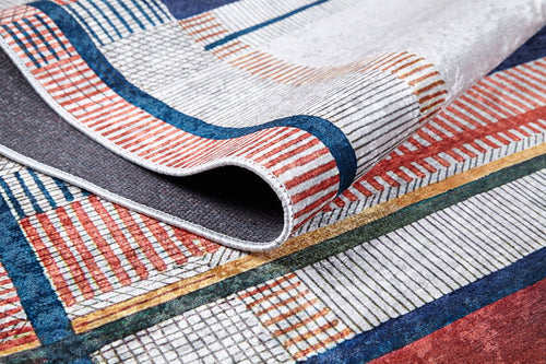 Load image 1 in gallery view. A close-up of the Bohemian Nightscape - Washable Rug (JR1701), featuring red, blue, gold, and white geometric patterns. Partially folded to highlight its texture and intricate details—ideal for high-traffic areas.