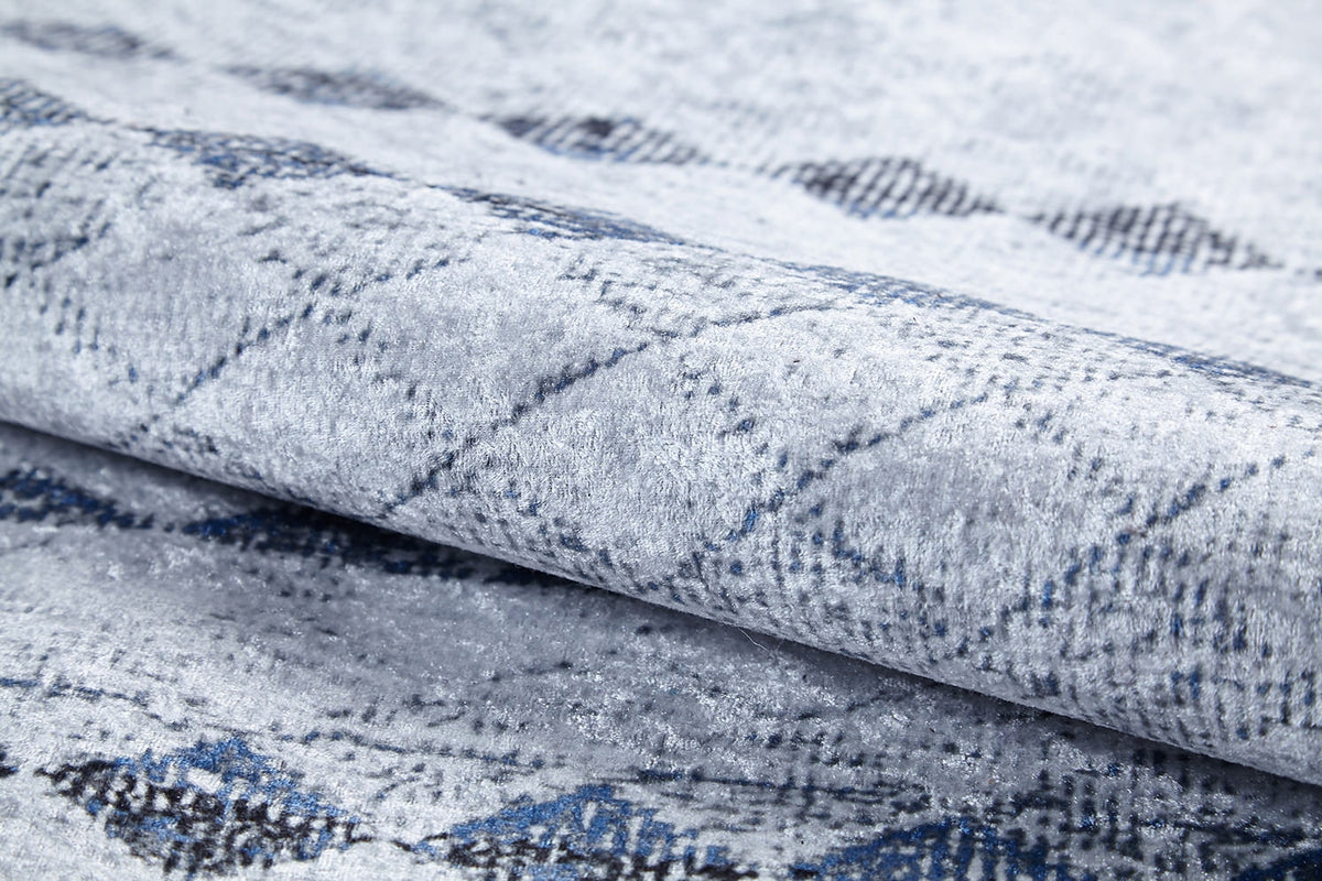 Close-up of the Bohemian Reverie - Washable Rug - JR1974 (Outlet) US, shown folded with a soft, textured surface and subtle diamond pattern in gray, blue, and black—ideal for high-traffic spaces.