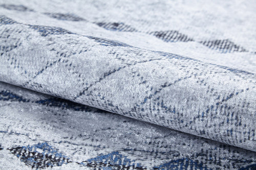 Bild 1 in Galerieansicht laden. Close-up of the Bohemian Reverie - Washable Rug - JR1974 (Outlet) US, shown folded with a soft, textured surface and subtle diamond pattern in gray, blue, and black—ideal for high-traffic spaces.