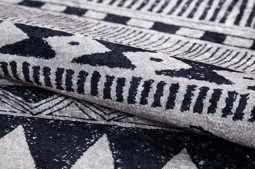 Load image 1 in gallery view. Close-up of the Bohemian Sunrise - Washable Rug - JR1713, folded to show its gray-anthracite hue with black and white geometric patterns—ideal for adding bold, durable texture to high-traffic spaces.