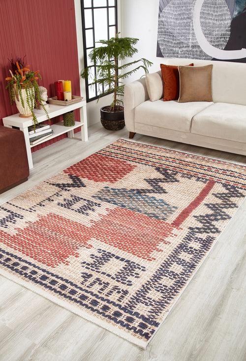 Bild 1 in Galerieansicht laden. A modern living room with a beige sofa, white coffee table with plants, potted tree, and the Boho Bliss - Washable Rug - JR1723 in red, blue, cream, and beige tones on a light wood floor.