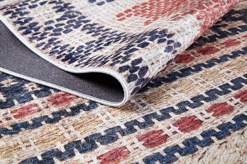 Bild 1 in Galerieansicht laden. A close-up of the Boho Bliss - Washable Rug - JR1723 showcases red, blue, and beige geometric patterns. A folded corner reveals the dark backing and stitched edge—ideal for fans of cream and beige rugs.