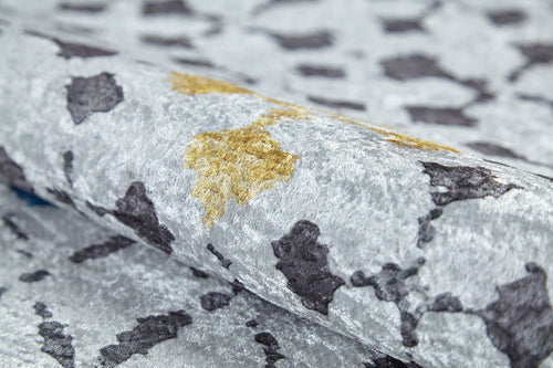 Load image 1 in gallery view. Close-up of the Boho Breeze - Machine-Washable Rug (JR5011): a rolled flat weave with a metallic sheen and abstract silver, black, and gold pattern—perfect as a stylish washable accent for modern interiors.