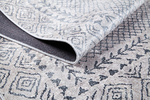 Load image 1 in gallery view. A close-up of the Borderline Brilliance - Washable Rug - JR1987 in beige and gray with geometric and diamond designs, featuring a folded corner to show the underside—perfect for high-traffic areas.