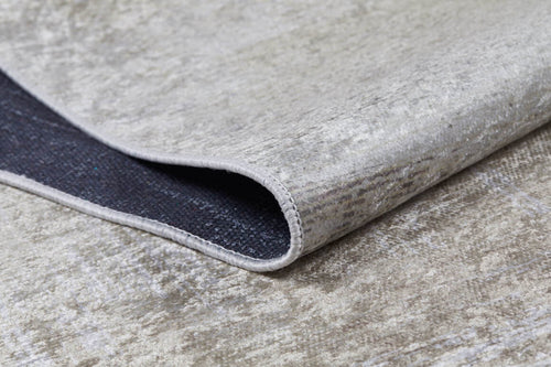 Load image 1 in gallery view. A close-up of the Cinnamon Swirl - Washable Rug - JR425 in cream and beige, featuring a textured surface, folded corner revealing the dark underside and stitched edging—ideal for high-traffic areas.