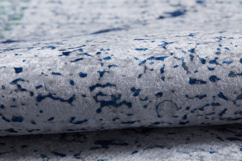 Load image 1 in gallery view. Close-up of the Classic Trellis - Washable Rug - JR710 in soft, light gray flat weave with textured surface and irregular navy blue speckled patterns. Slight folding adds charm, making it ideal for a modern living room.