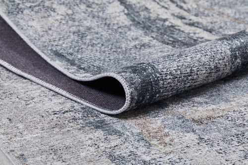 Load image 1 in gallery view. A close-up of the Classic and Bold - Washable Rug - JR1529 in modern gray-anthracite with a textured, abstract pattern. One edge is folded to reveal the dark underside and stitched border—ideal for high-traffic areas.