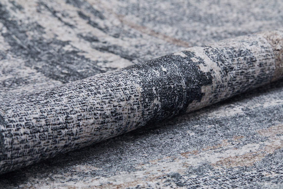 Close-up of the Classic and Bold - Washable Rug - JR1529, featuring a rolled, textured gray-anthracite surface with a soft, subtly distressed gray, black, and white abstract pattern—perfect for high-traffic areas.