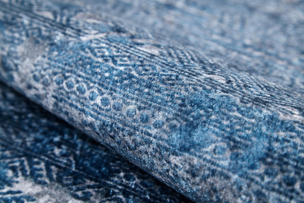 A close-up of the Contemporary Serenity - Machine-Washable Rug JR1884, featuring intricate geometric and circular designs in various blue and white shades—ideal for high-traffic areas.