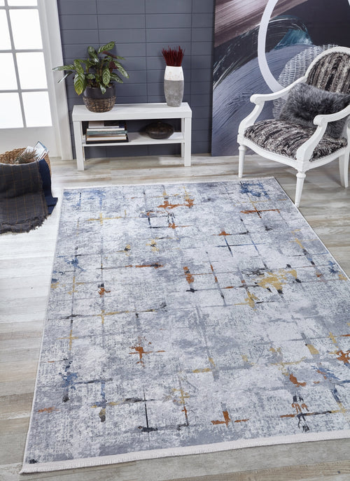 Bild 1 in Galerieansicht laden. A modern living room features the Cross Country - Washable Rug - JR1753 in gray with an abstract pattern, a white cushioned chair, small white table with plants and decor, abstract painting, gray wall, and light wood flooring for a bright look.