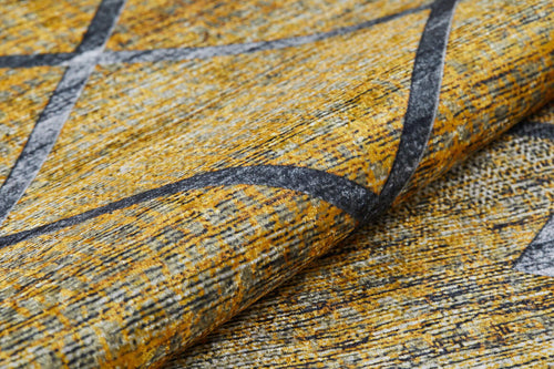 Load image 1 in gallery view. A close-up of the Crossed Connections - Washable Rug - JR1181 shows its yellow and gray geometric design with intersecting dark gray lines. Slight fabric folds highlight its texture. Ideal for high-traffic areas and easy to clean.