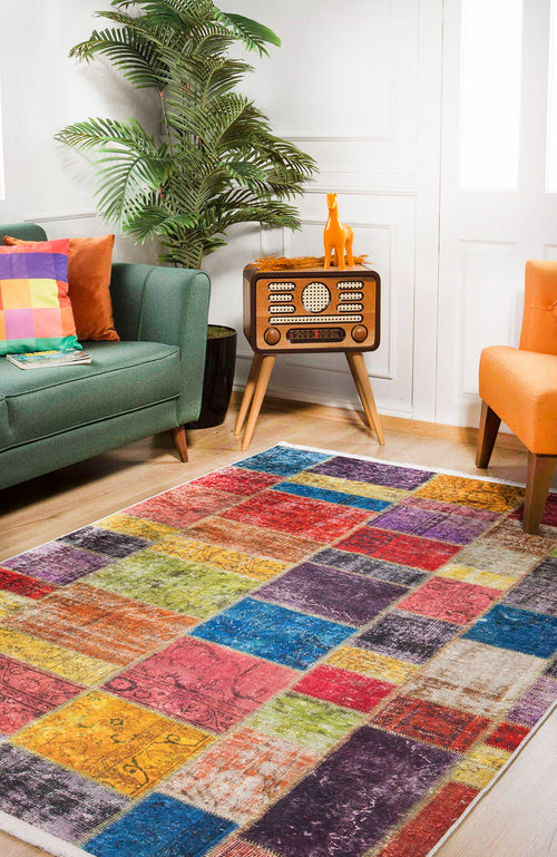 Load image 1 in gallery view. The Crosshatch Craze - Washable Rug - JR210 adds vibrant color to a bright living room with a green sofa, orange chair, retro radio stand, plant, and yellow dog figurine—perfect for high-traffic areas.