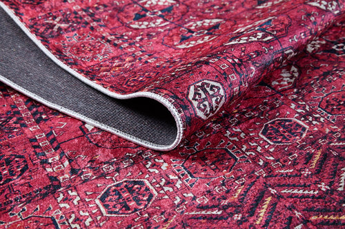 Load image 1 in gallery view. A close-up of the Desert Dreamscape - Washable Rug - JR1940 shows its red geometric pattern and durable design, with one corner lifted to reveal the dark gray underside.