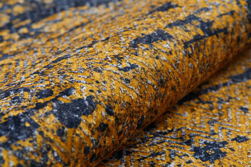 Load image 1 in gallery view. A close-up of the Diagonal Dash - Washable Rug - JR1310 shows its mottled yellow, black, and gray abstract geometric pattern. Soft with visible fibers and a slightly raised surface, it’s durable and perfect for high-traffic areas.