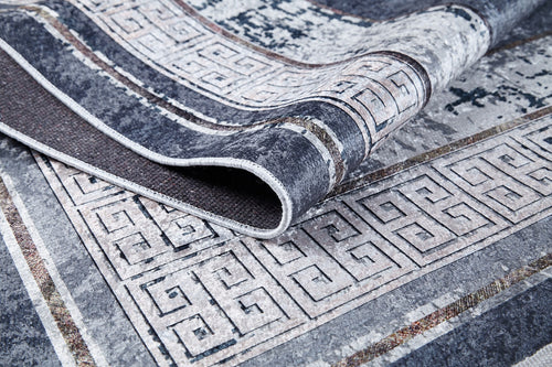 Load image 1 in gallery view. A close-up of the Dramatic Boundaries - Washable Rug - JR1810 shows its folded geometric Greek key pattern in shades of gray, white, and black—durable texture and intricate detailing make it ideal for high-traffic areas.