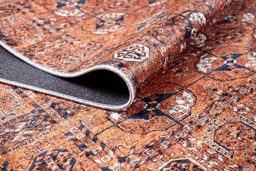 Load image 1 in gallery view. A close-up of the Earthy Enigma - Washable Rug - JR1937 shows its intricate rust-colored pattern; one edge curls to reveal the dark non-slip backing—ideal for high-traffic areas.