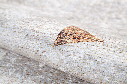 Load image 1 in gallery view. A close-up of the Ebony Ivory - Washable Rug (JR1994), rolled to reveal its beige surface with small brown and orange triangles—an ideal choice for allergy-sensitive households and busy, high-traffic areas.