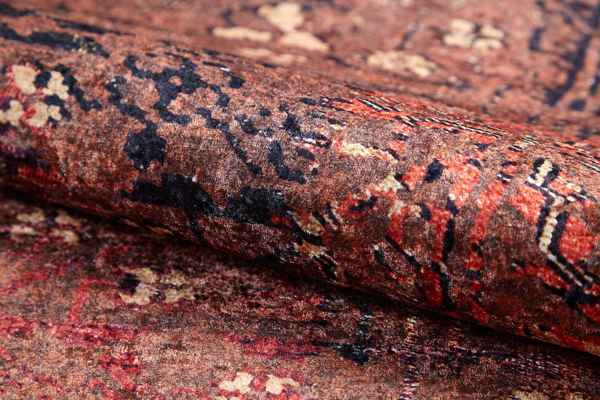 A close-up of the Ethereal Elegance - Washable Rug - JR1651 showcases intricate patterns in brown, red, black, and beige. This durable rug is ideal for high-traffic areas, highlighting the rich texture and detail of bronze and brown rugs.