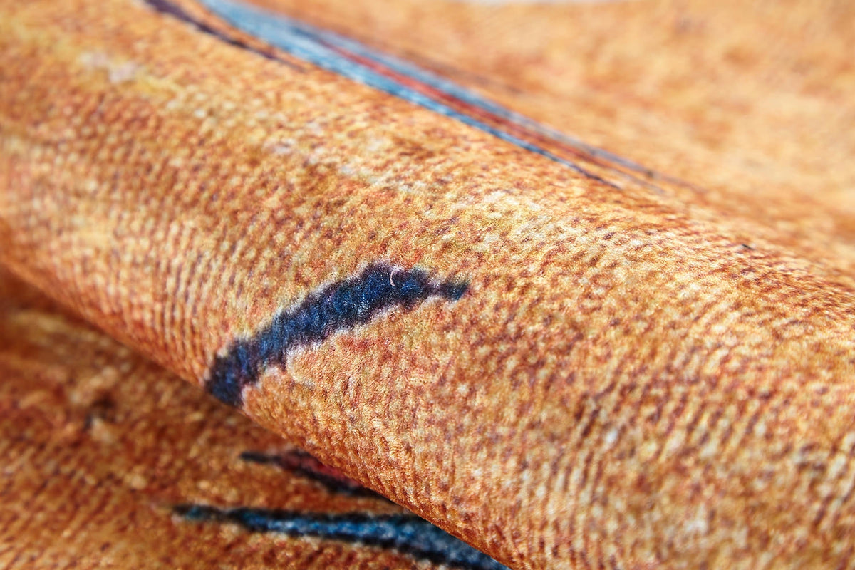 A close-up of the Floral Mosaic - Washable Rug - JR1720 reveals its textured orange weave with blue and dark brown streaks, highlighting the soft surface—perfect for high-traffic areas and easy to wash.