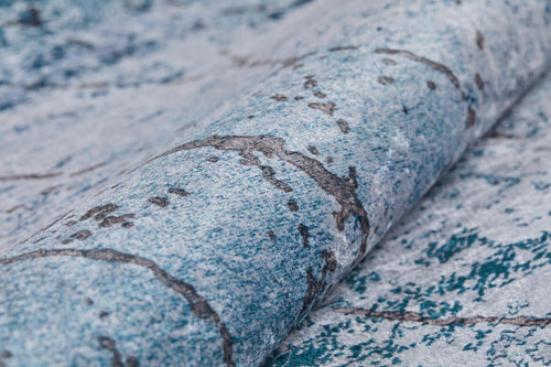 Load image 1 in gallery view. Close-up of the Geometric Glimmers washable rug (JR1423) with a blue and gray marbled pattern featuring subtle veining—a stylish, durable choice that pairs perfectly with blue accents in high-traffic areas.