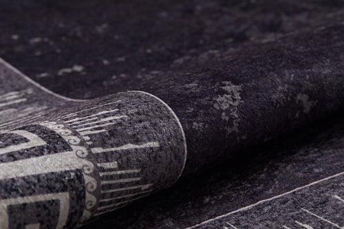 Load image 1 in gallery view. A close-up of the Geometric and Chic - Washable Rug - JR1273, partially rolled up to show its dark, textured surface with gray tones and intricate linear patterns—perfect for high-traffic areas.