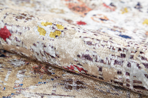 Bild 1 in Galerieansicht laden. A close-up of the Global Getaway - Washable Rug - JR1667 in cream and beige, featuring a soft velvety texture with abstract red, yellow, brown, and blue accents. Partially rolled to reveal its sheen and detailed design—ideal for high-traffic areas.