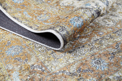 Load image 1 in gallery view. A close-up of the Golden Oasis - Washable Rug - JR1930 shows a folded corner revealing its textured backing. The rug displays an intricate yellow, blue, and white design with a slightly distressed look, ideal for high-traffic areas.