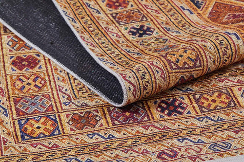 Load image 1 in gallery view. A close-up of the Grandiose Grace - Washable Rug - JR44 shows its multicolored geometric patterns in red, gold, blue, and brown. A folded corner reveals the dark underside—ideal for high-traffic areas.