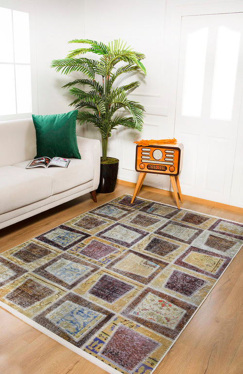 Load image 1 in gallery view. A living room with a white sofa, green cushion, potted plant, vintage radio on a stand, open magazine, and the Gridiron Glow - Washable Rug - JR183—perfect for high-traffic areas. White walls and large windows invite natural light.