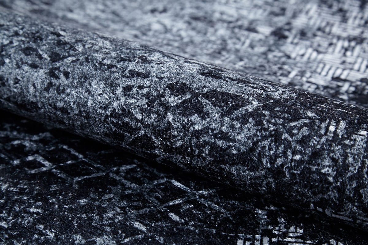 Close-up of the Infinity Garden - Washable Rug - JR1749: a rolled gray-anthracite rug with an abstract black and gray geometric pattern—stylish, washable, and perfect for high-traffic areas.
