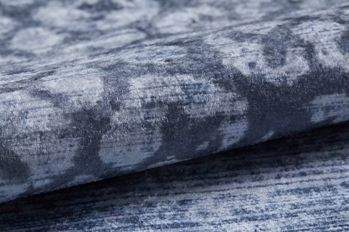 A close-up of the Intricate Scroll - Washable Rug - JR342 in blue and gray with a textured abstract pattern, folded on a flat surface—washable design ideal for allergy-sensitive homes and high-traffic areas.