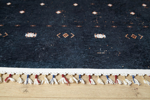 Load image 1 in gallery view. A close-up of Midnight Majesty - Machine-Washable Rug (JRS5052), featuring dark blue tones, small geometric patterns, a white edge, and red, white, and blue fringe—perfect for high-traffic wooden floors.