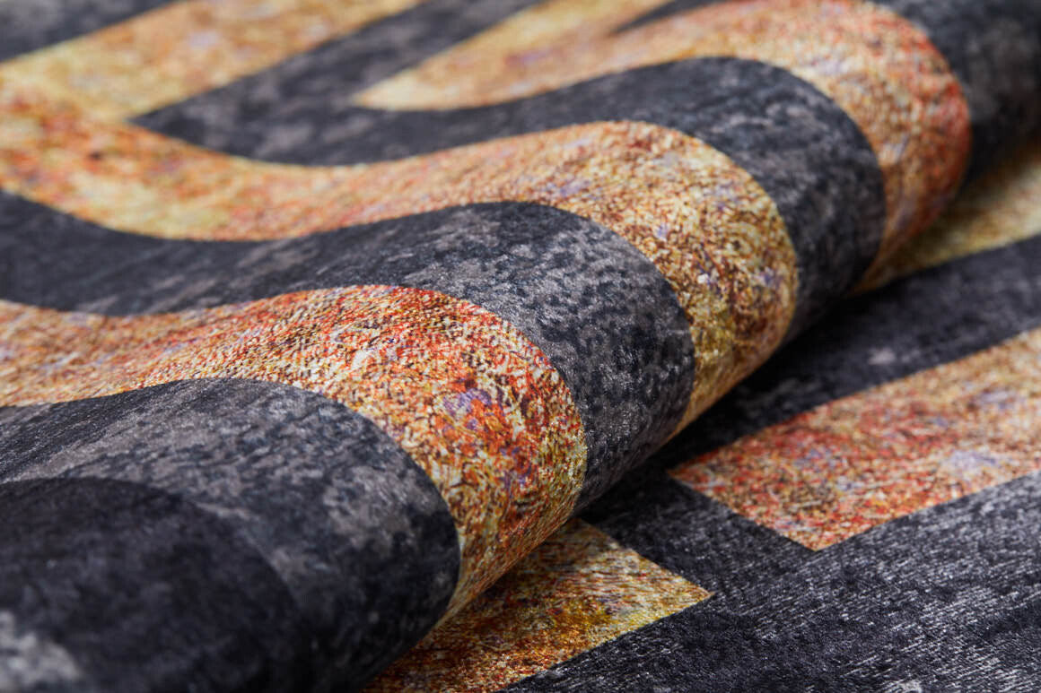 A close-up of the Minimalist and Clean - Washable Rug - JR1407, featuring textured, wavy stripes in dark gray and mottled orange-gold—showing rich detail and folds. Ideal for high-traffic areas.