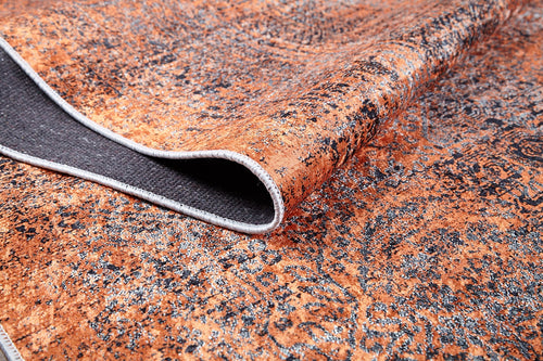 Load image 1 in gallery view. A close-up of the Modern Mosaic - Machine-Washable Rug JR1846 shows its textured orange and black pattern, a folded corner revealing its plain dark underside and stitched edge—perfect for high-traffic spaces.