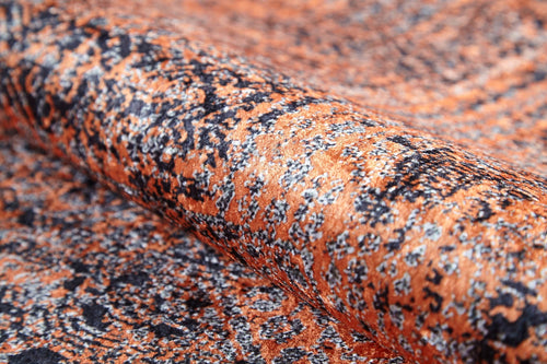 Load image 1 in gallery view. A close-up of the Modern Mosaic - Machine-Washable Rug JR1846 reveals its orange and black pattern, detailed texture, and intricate mottled design. The gently folded material highlights this rug’s softness and durability for high-traffic areas.