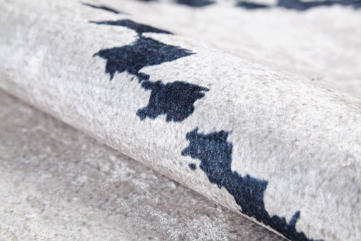 Close-up of the Moroccan Mosaic - Washable Rug - JR1655 in light gray-anthracite, featuring a soft, textured surface and abstract dark blue and black patterns; shown partially rolled to display its plush material—ideal for high-traffic areas.