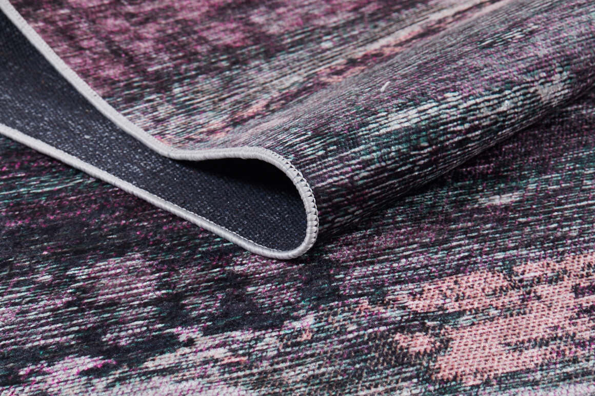 A close-up of the Natural Brushed - Washable Rug - JR336 in pink, purple, and dark gray shows its textured surface and darker woven underside, perfect for high-traffic areas and easy cleaning.