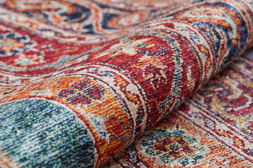 Load image 1 in gallery view. A close-up of the Old-World Elegance - Washable Rug - JR38 (Outlet) US showcases its colorful, intricate red, orange, blue, and cream patterns with detailed weaving and texture as the washable rug is partially rolled.