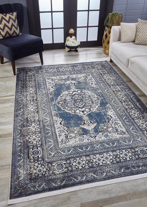Load image 1 in gallery view. A room with the Opulent Beauty - Washable Rug - JR1932 in blue and white on a wooden floor, a dark armchair, beige sofa, decorative vase, and French doors with frosted glass panels in the background—ideal for high-traffic areas.