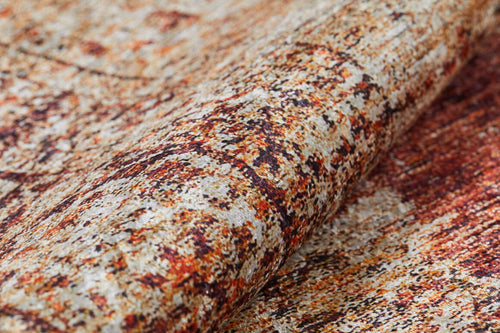 Load image 1 in gallery view. Close-up of the Ornate Grace - Washable Rug - JR1009, showing its textured, mottled pattern in brown, orange, beige, and cream. The slightly folded fabric adds to its abstract, weathered look—perfect for high-traffic spaces.