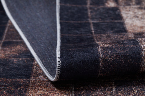 Load image 1 in gallery view. A close-up of the Pinstripe Paradise - Washable Rug (JR1004) in a dark tone features a subtle square pattern, one edge lifted to reveal stitching and the underside.